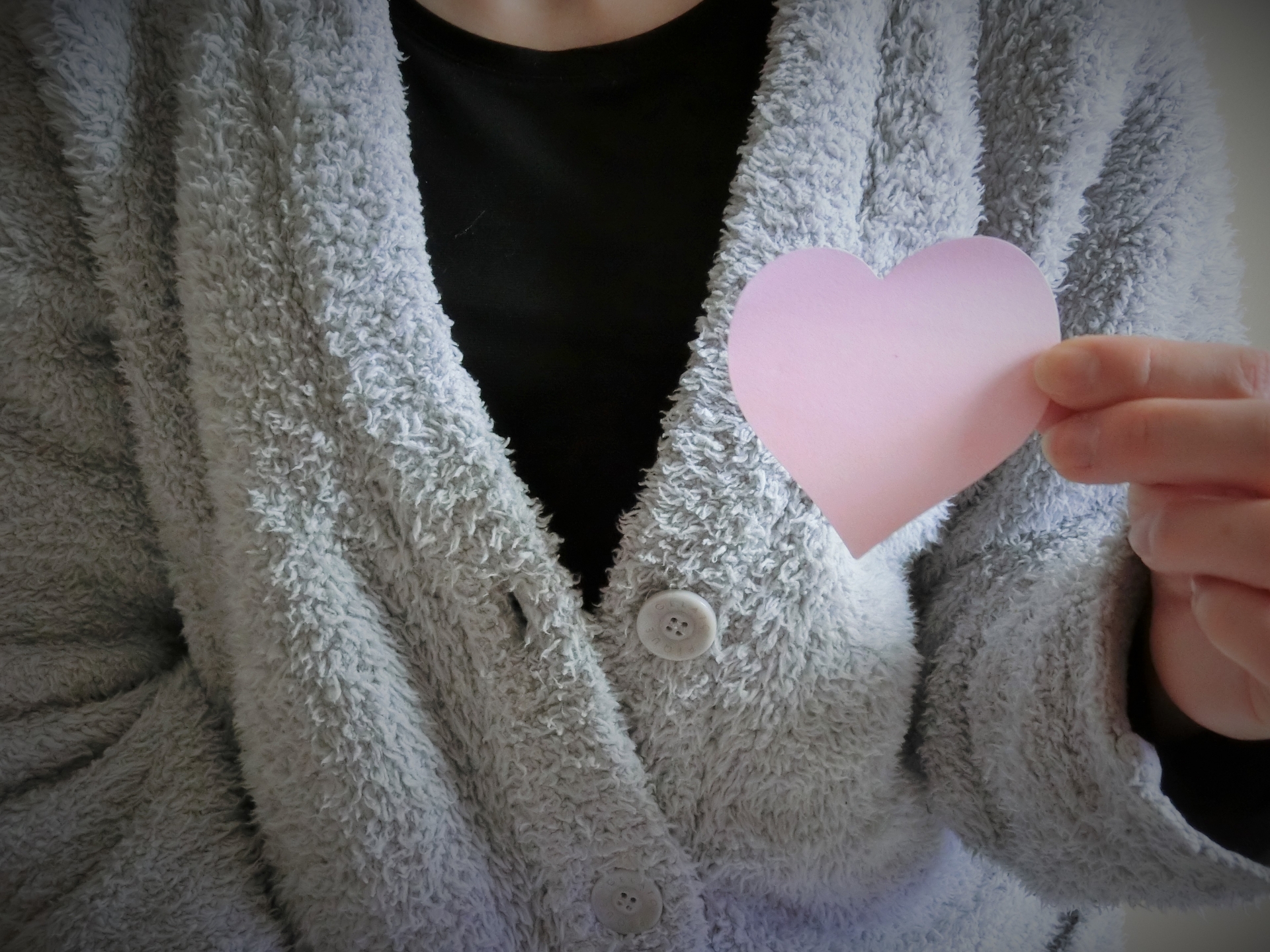 ハートを胸に持つ女性の手元