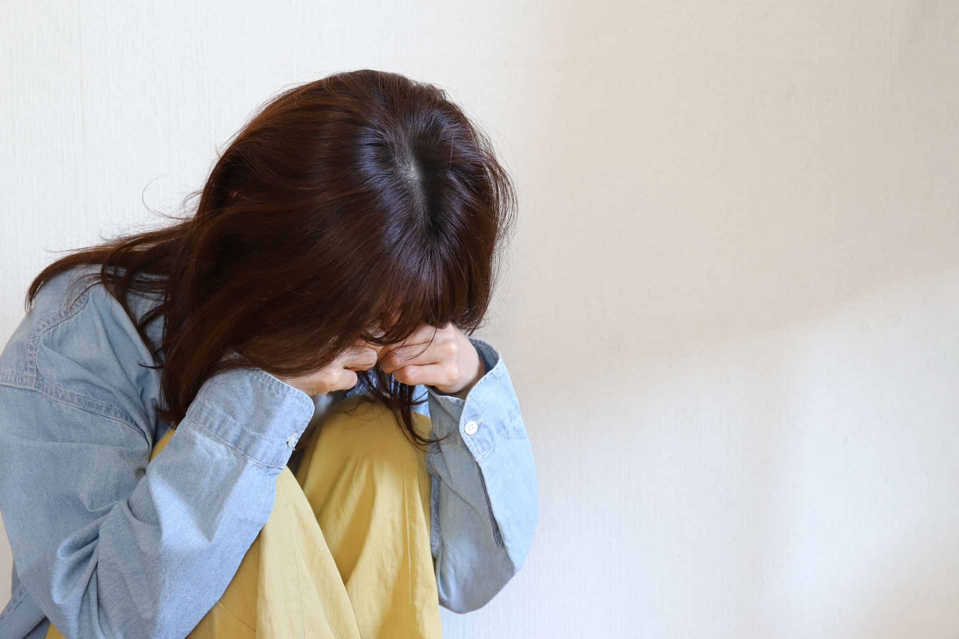顔を覆って泣く女性