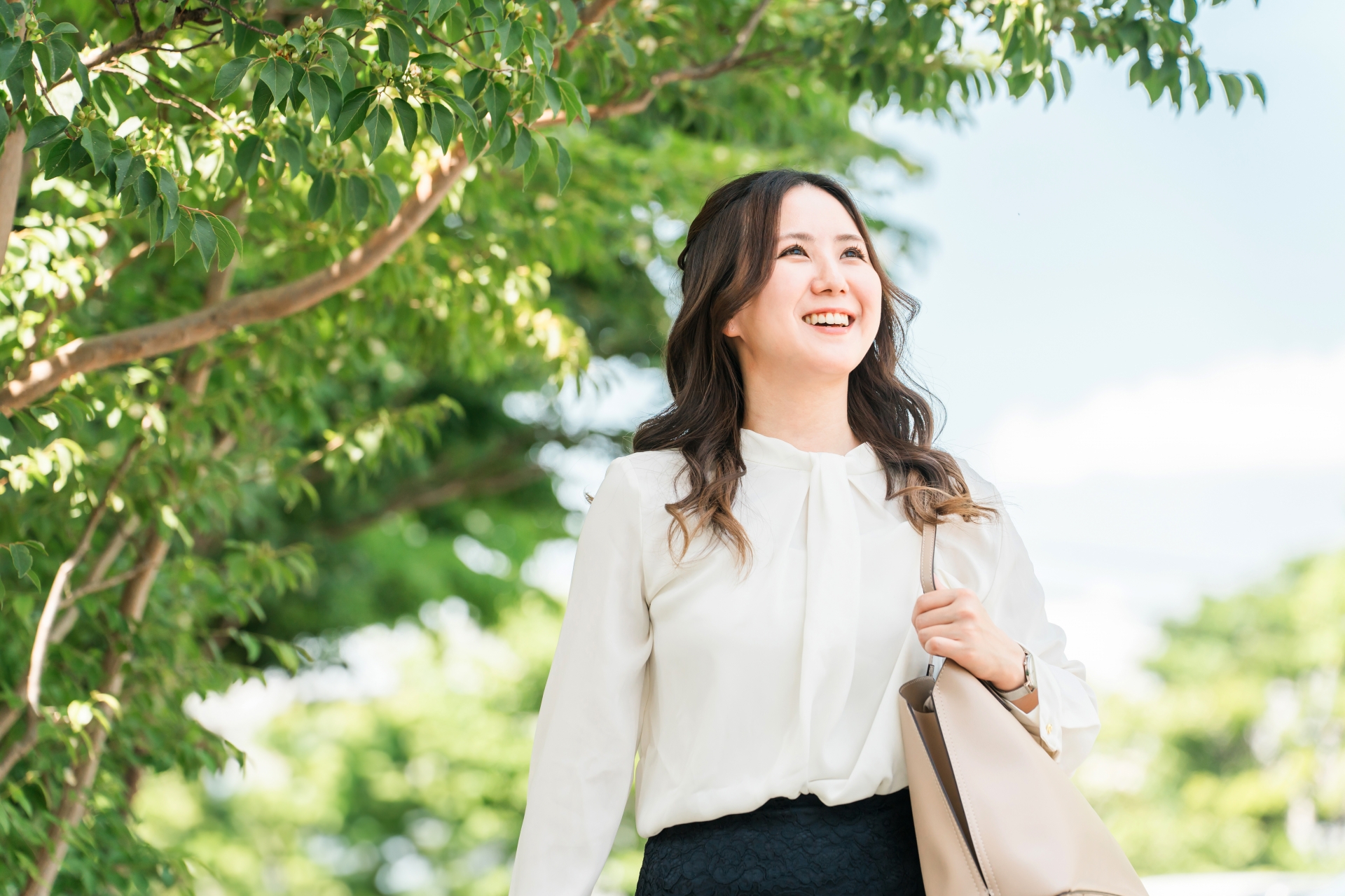 緑の中を前向きに歩く女性