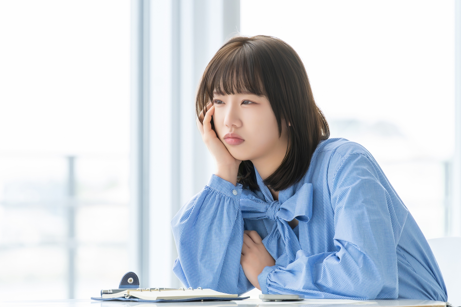 頬杖をついて悩む女性