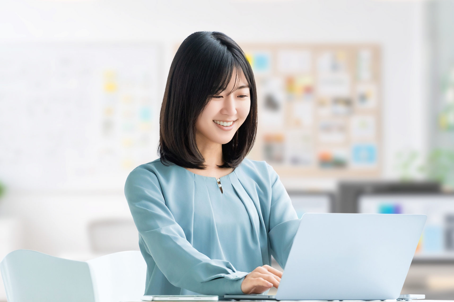 自宅でパソコン作業をする笑顔の女性